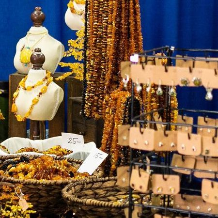 A man is looking at necklaces on display at a convention