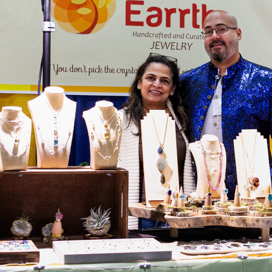 A man is looking at necklaces on display at a convention