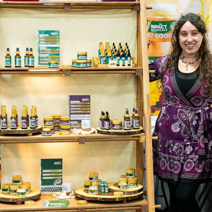 A man stands in front of a sign that says sam 's soulutions