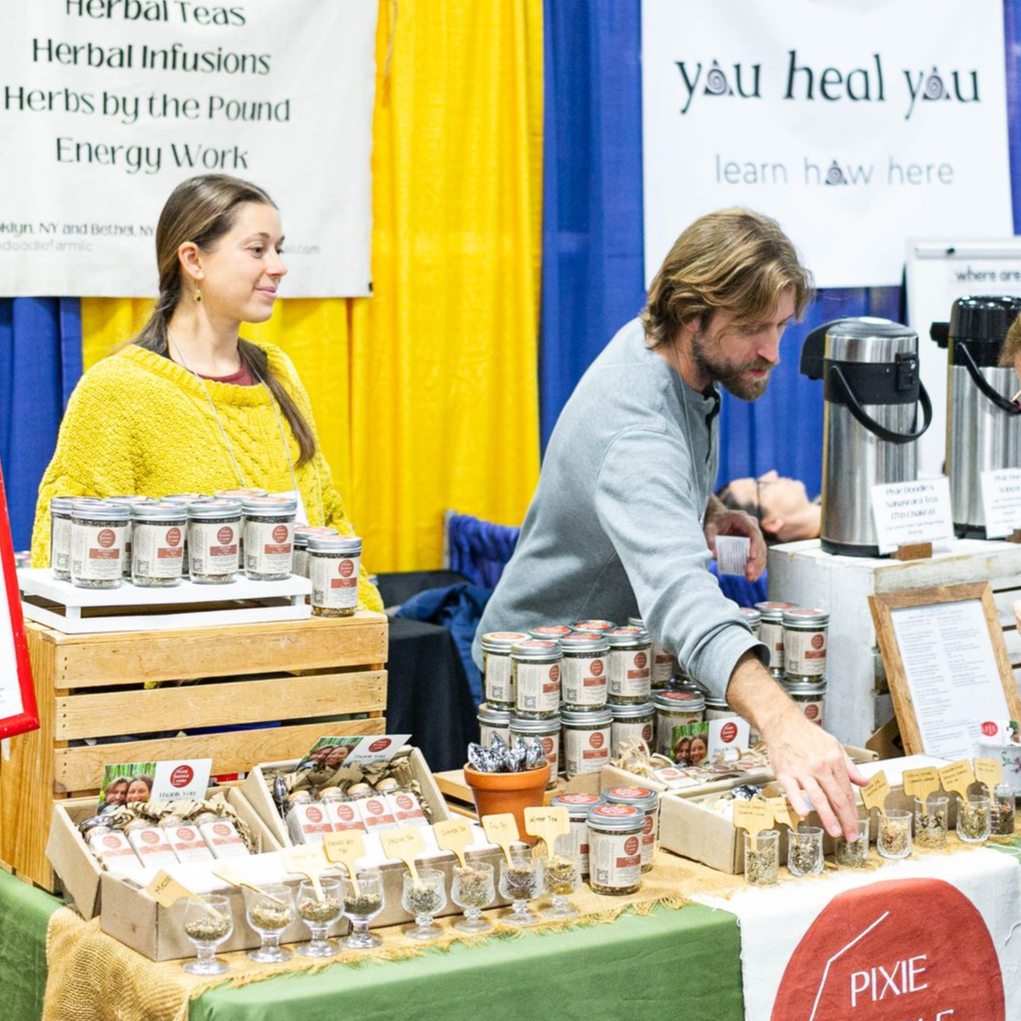 A woman wearing a flowered hat is looking at her phone
