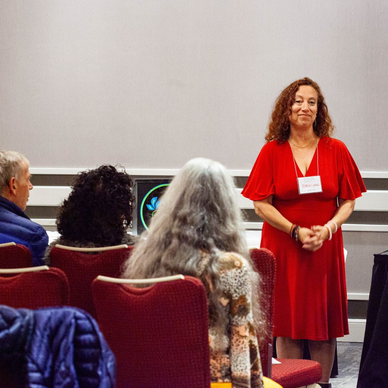 A woman is giving a presentation in front of a group of people