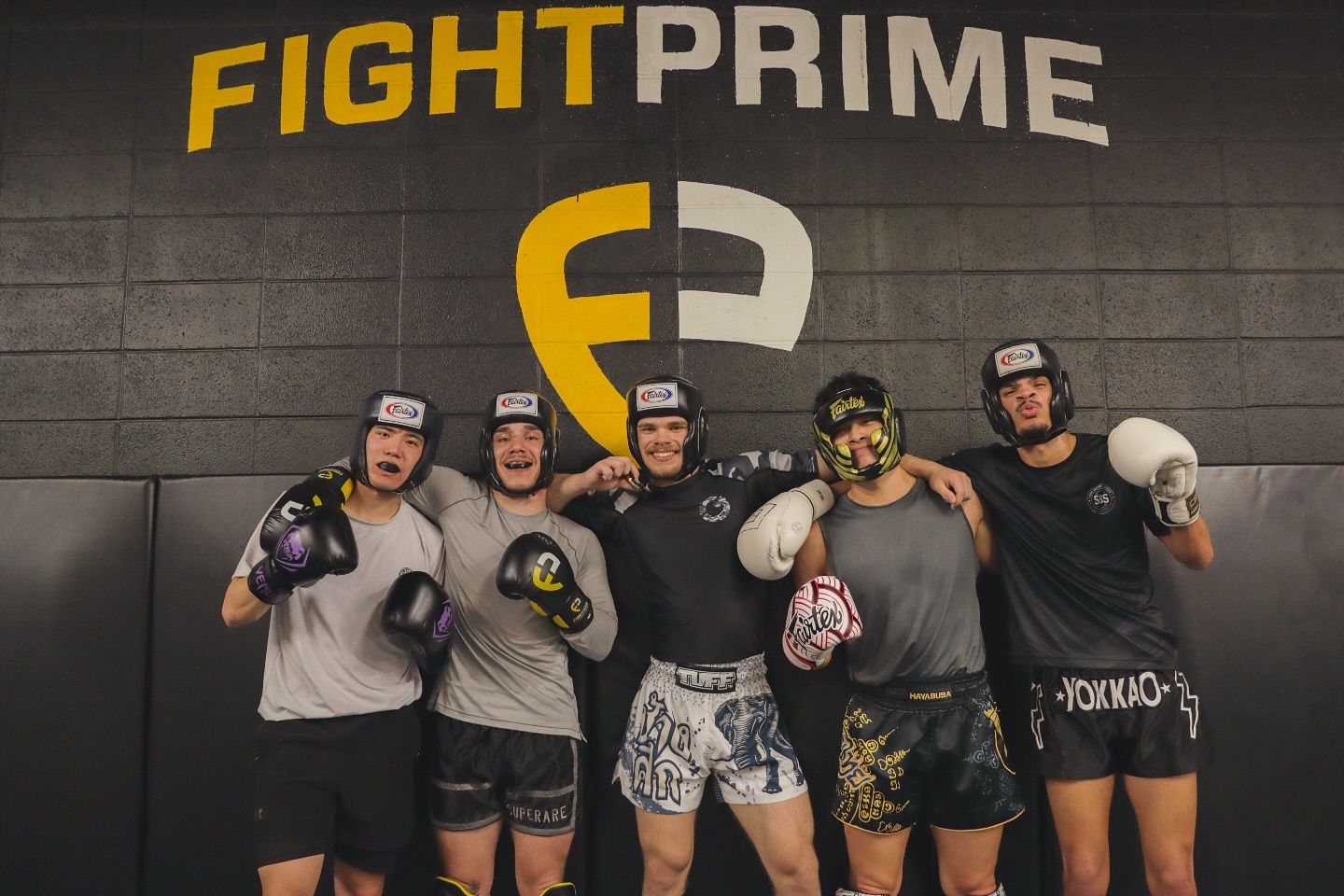 A group of men are posing for a picture in front of a fight prime sign.