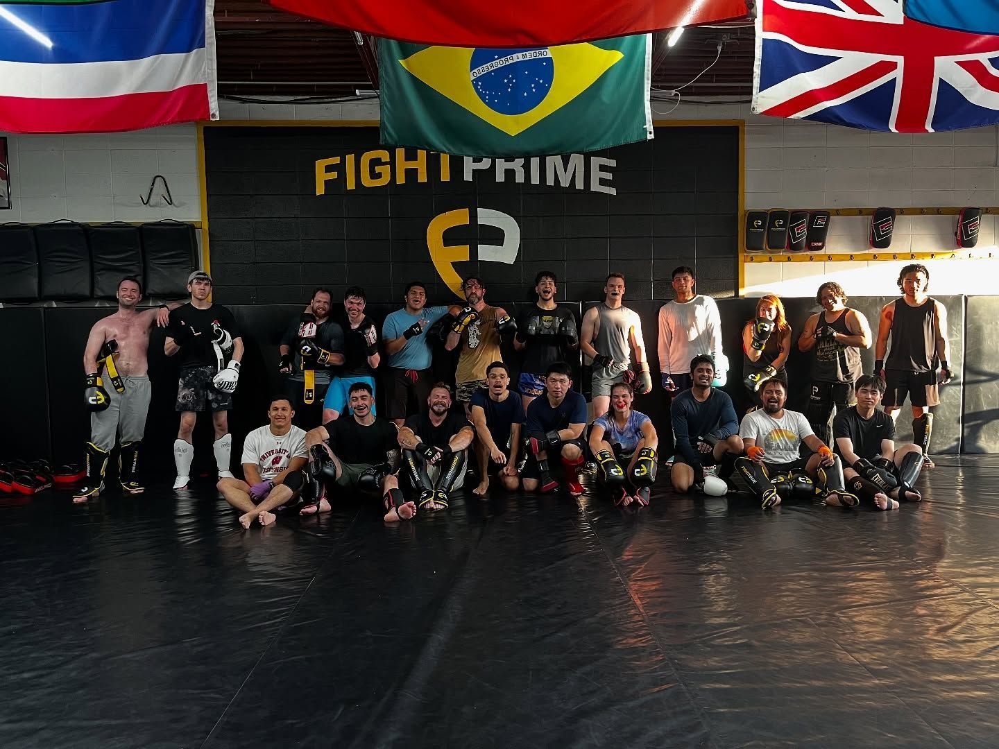 A group of people are posing for a picture in front of a sign that says fight prime