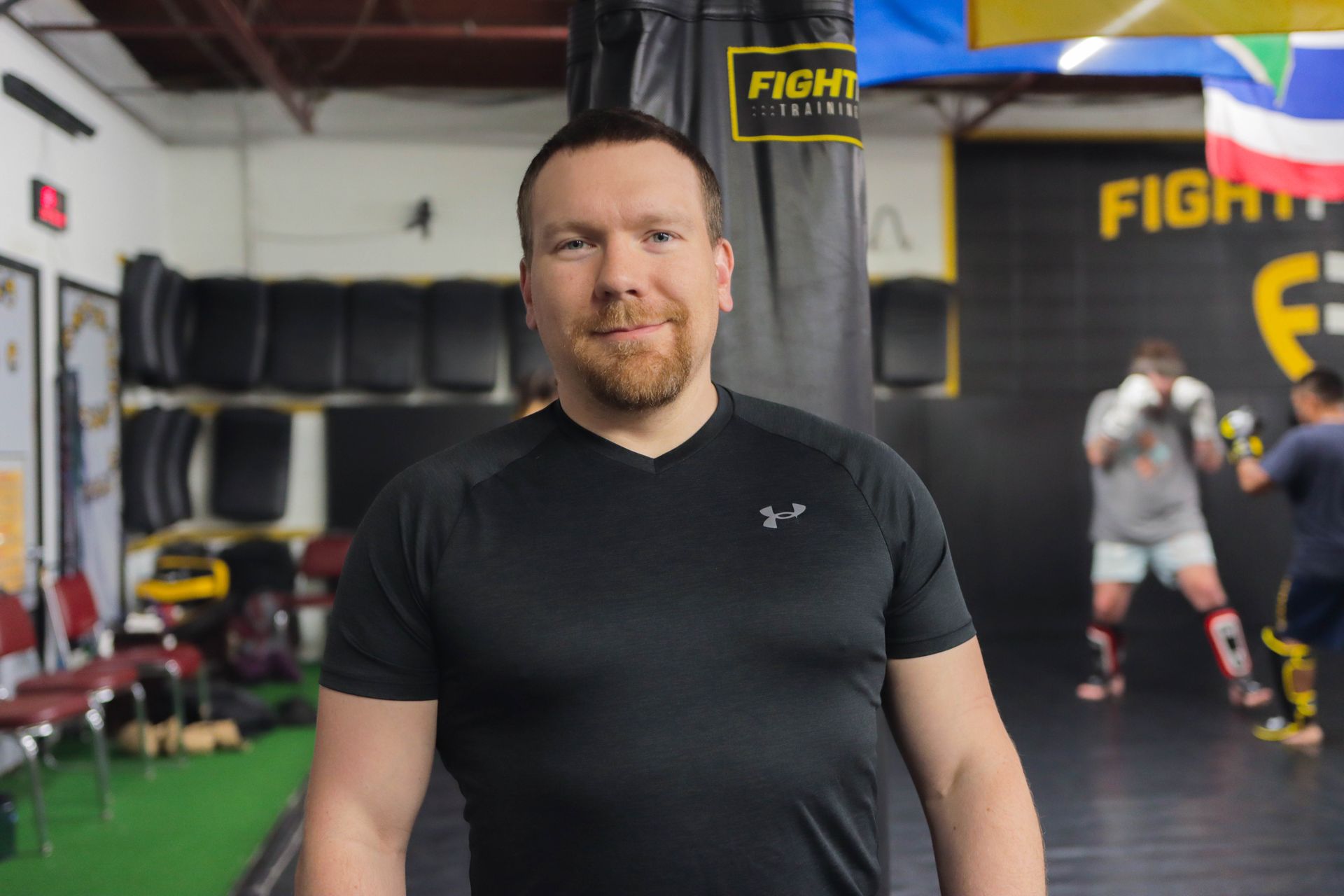 A man in a black shirt is standing and smiling