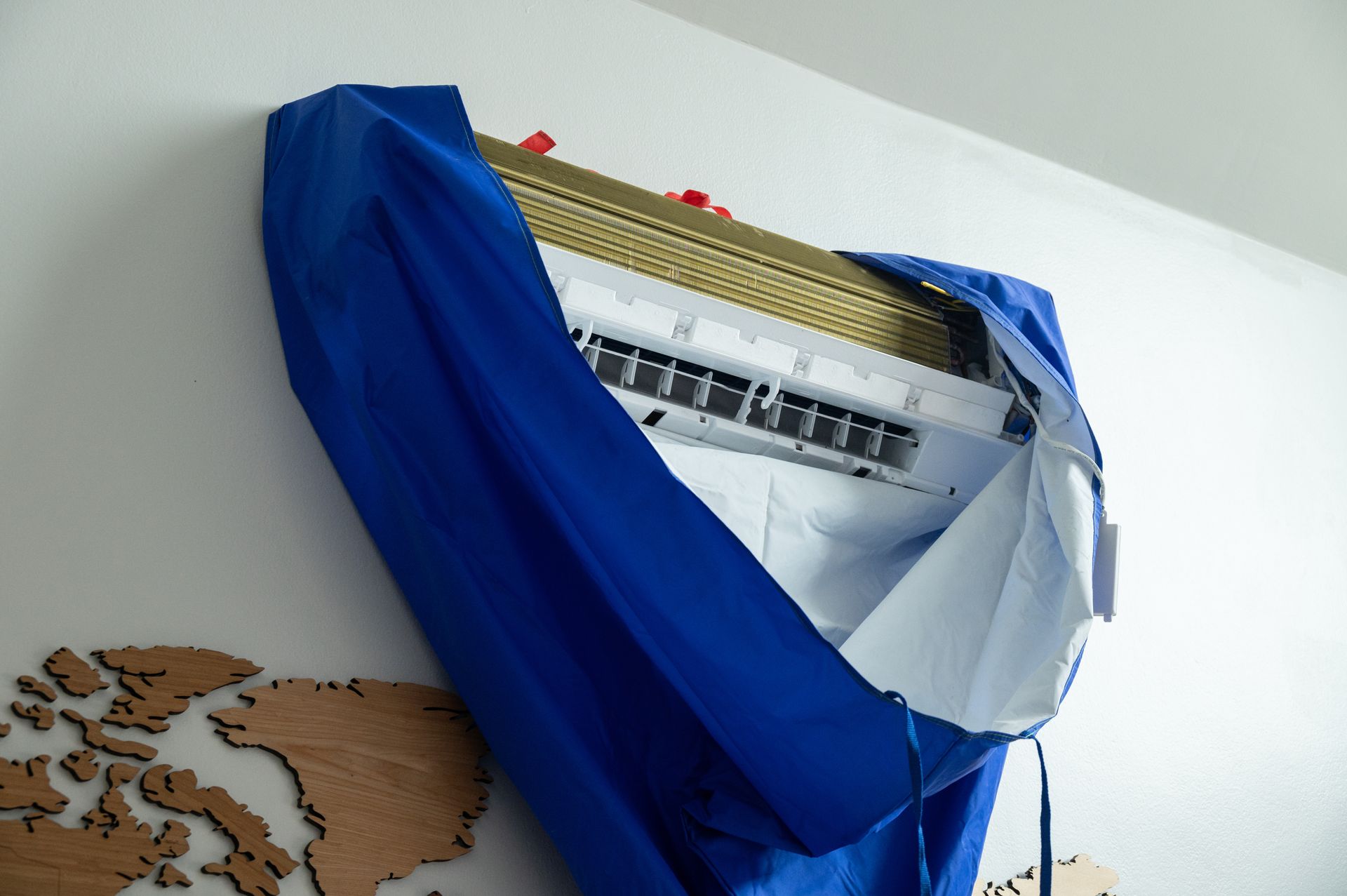 An air conditioner is covered in a blue cloth.