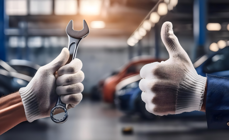 Mechanic hands in gloves holding a wrench, another hand giving a thumbs up in a garage | Mike's Automotive AC