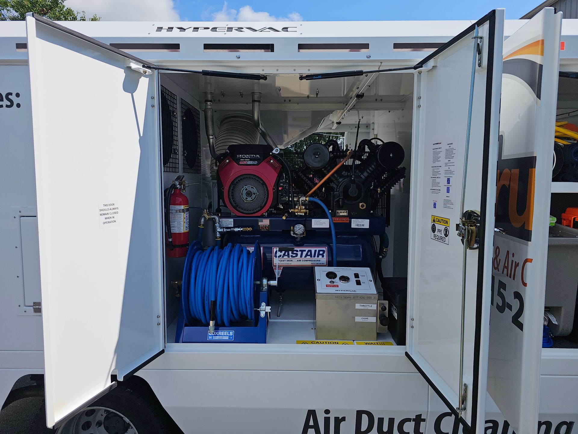 Air duct cleaning truck compartment with industrial equipment and hoses from A Guy in a Truck.