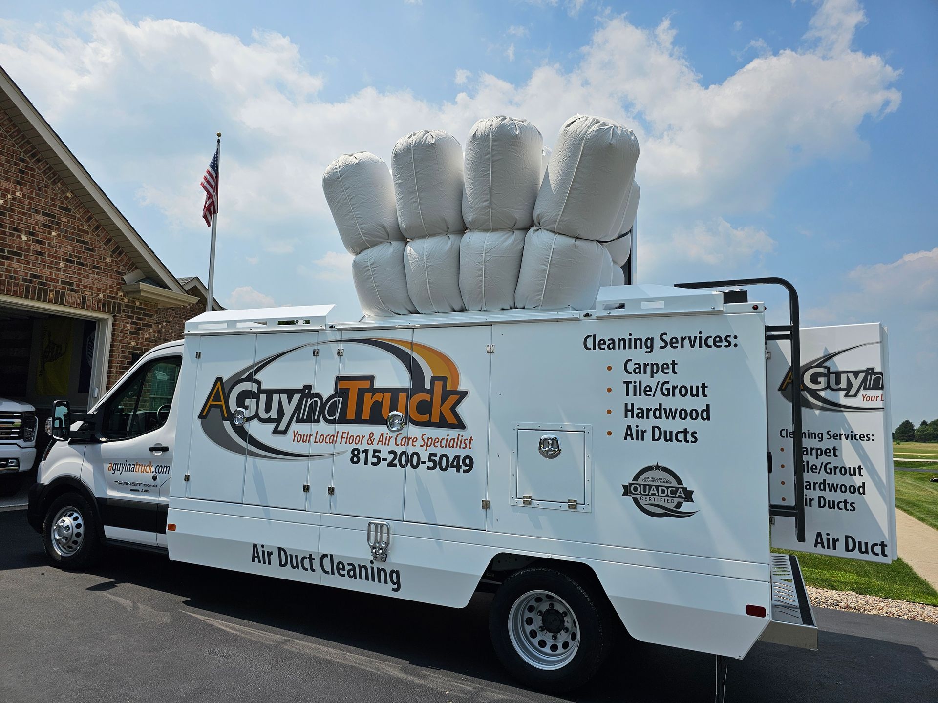A Guy in a Truck residential air duct cleaning truck parked outside home with vacuum equipment ready for service.