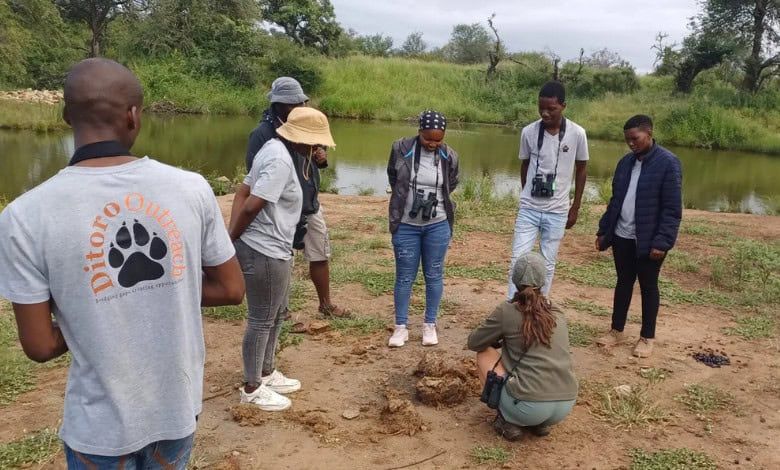 A group of people are standing around a body of water.