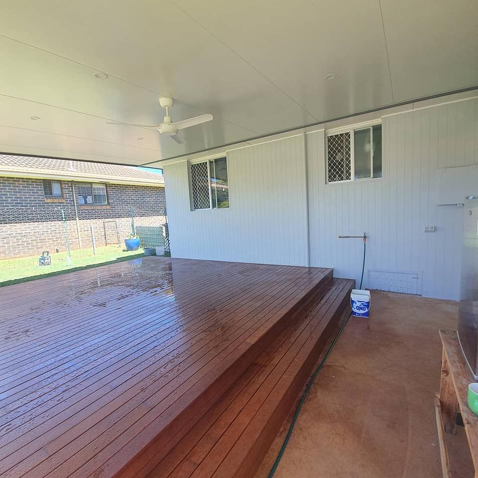 A Wooden Deck With Stairs Leading Up to It Under a Ceiling Fan — Jason Walsh Constructions in Ballina, NSW