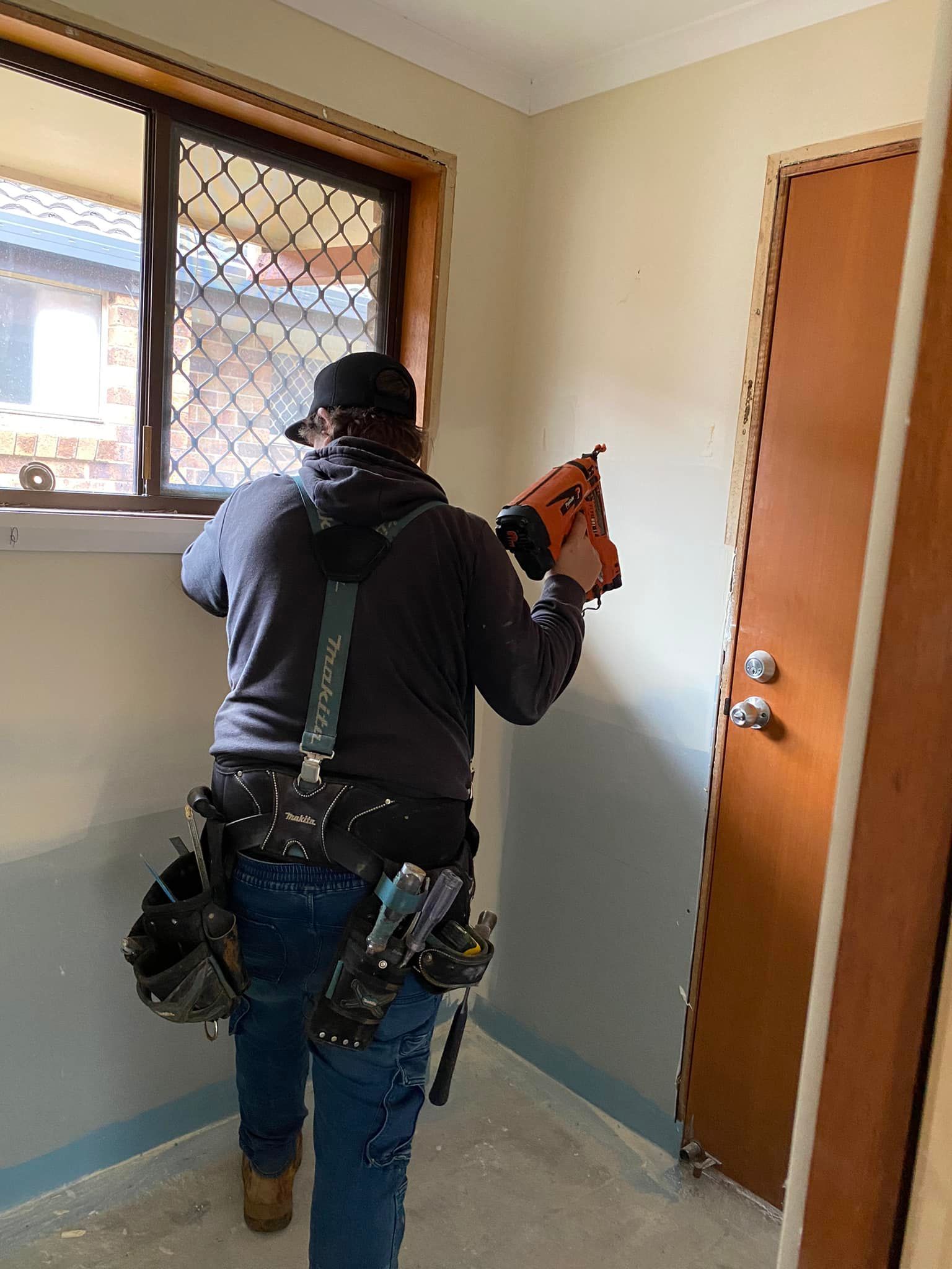 A man is standing in a room holding a drill — Jason Walsh Constructions in Alstonville, NSW