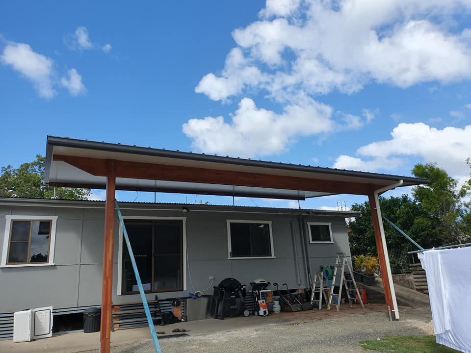 A gray house with a wooden porch and a blue sky in the background — Jason Walsh Constructions in Alstonville, NSW