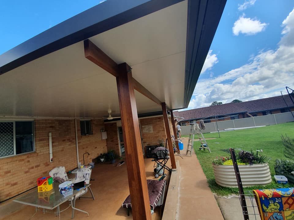 A patio with a table and chairs under a roof — Jason Walsh Constructions in Alstonville, NSW