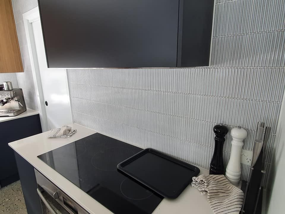 A Kitchen With a Stove Top Oven and a Black Tray on the Counter — Jason Walsh Constructions in Lismore, NSW