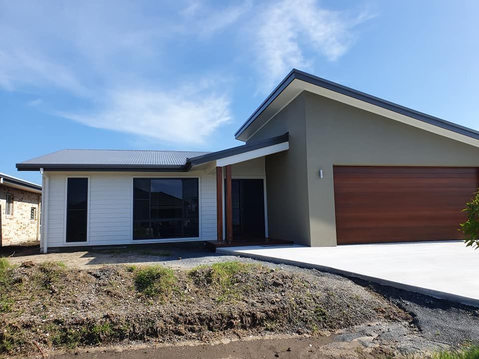 A White House With a Brown Garage Door and a Blue Sky in the Background — Jason Walsh Constructions in Alstonville, NSW