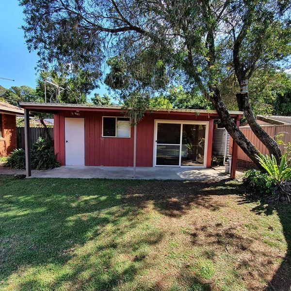 A small red house with a sliding glass door — Jason Walsh Constructions in Lennox Head, NSW