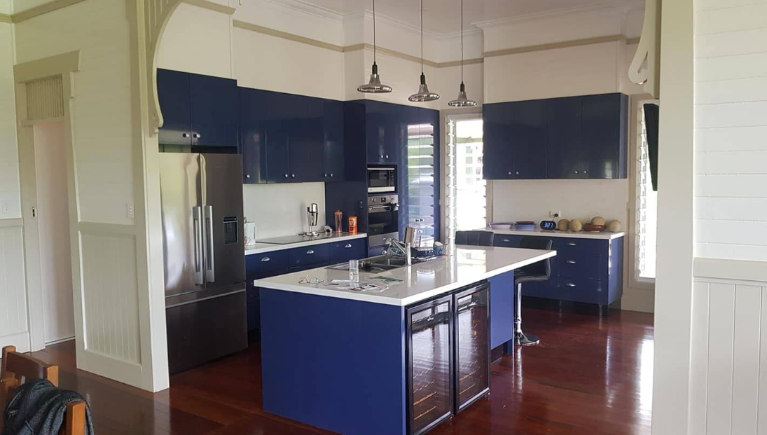 A kitchen with blue cabinets and a large island — Jason Walsh Constructions in Lismore, NSW