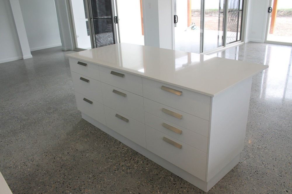 A large white island with drawers and a counter top in a kitchen — Jason Walsh Constructions in Lennox Head, NSW