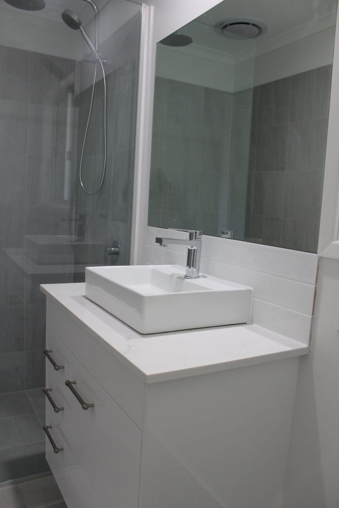 A Bathroom With a Sink, Mirror and Shower — Jason Walsh Constructions in Bangalow, NSW