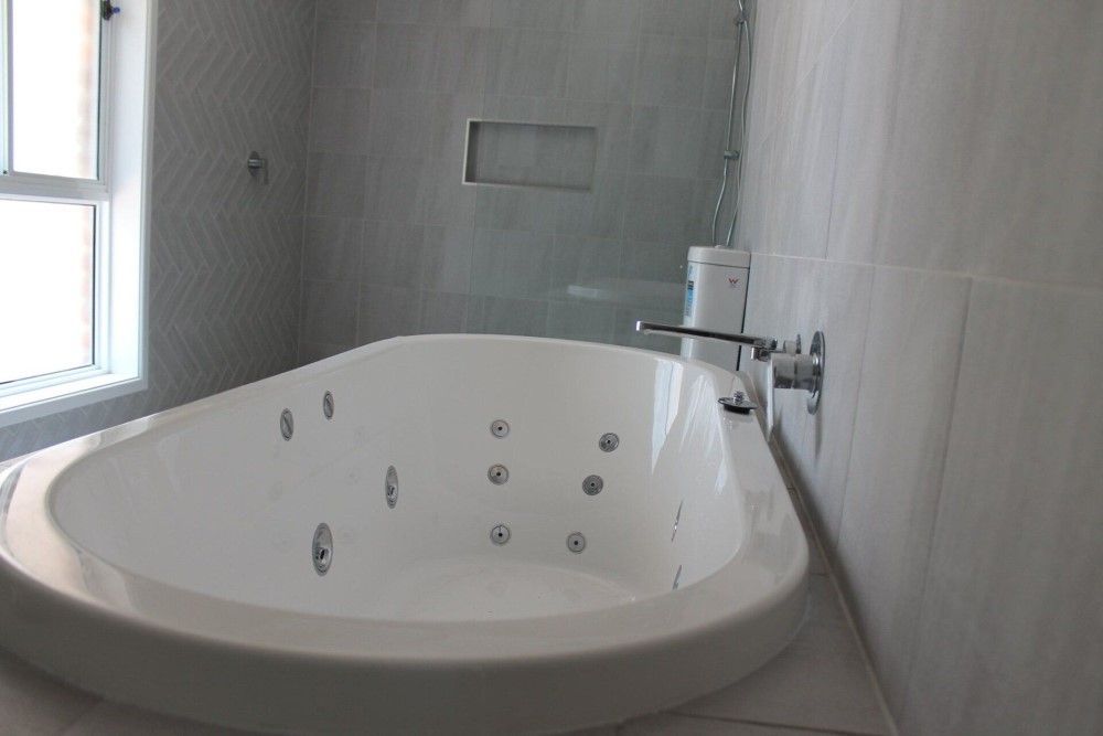 A Bathroom With a Jacuzzi Tub and a Shower — Jason Walsh Constructions in Bangalow, NSW