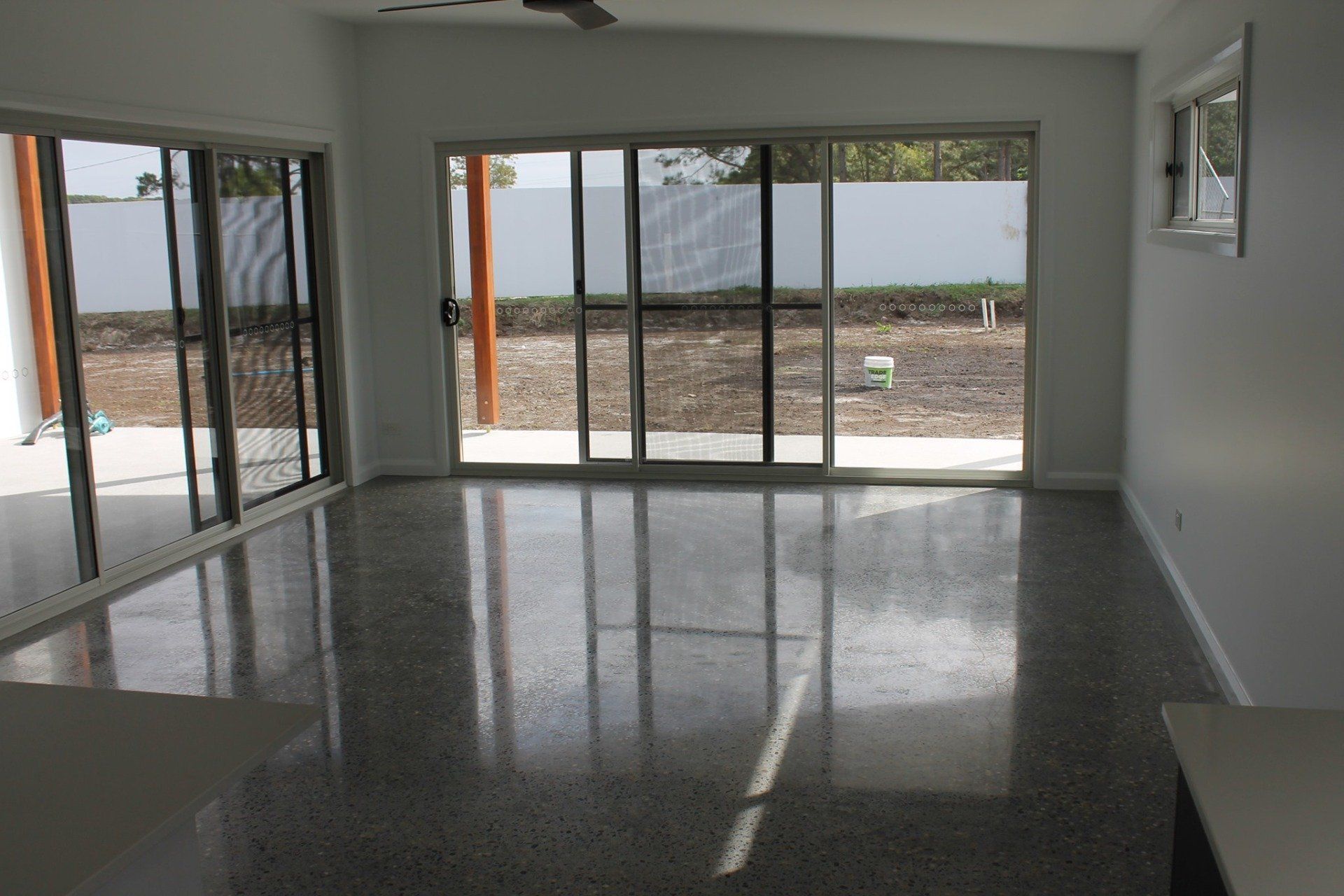 An empty room with sliding glass doors and a ceiling fan — Jason Walsh Constructions in Lennox Head, NSW