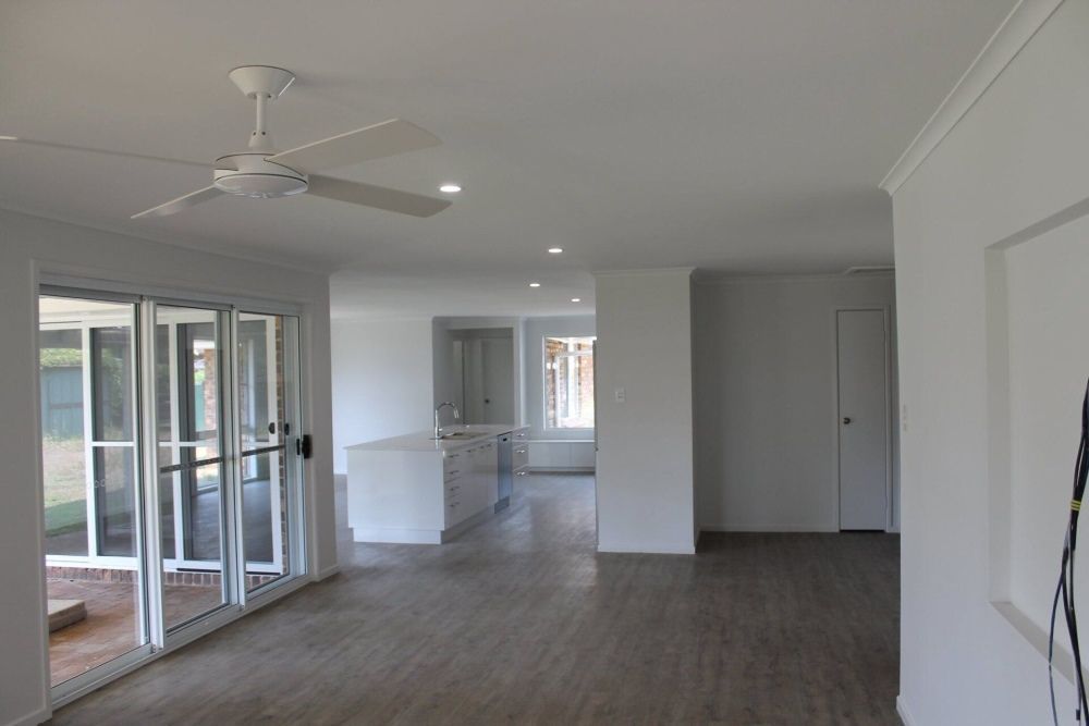 An Empty Room With a Ceiling Fan and Sliding Glass Doors — Jason Walsh Constructions in Lismore, NSW