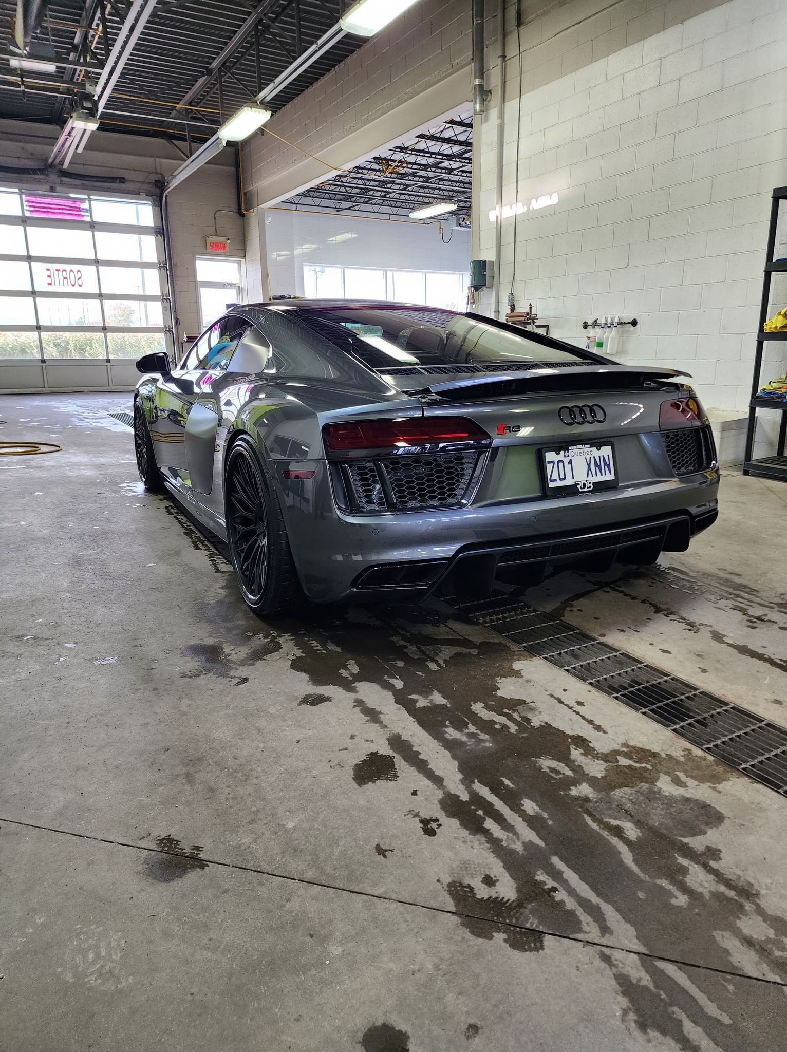 Une Audi R8 argentée est garée dans un garage.