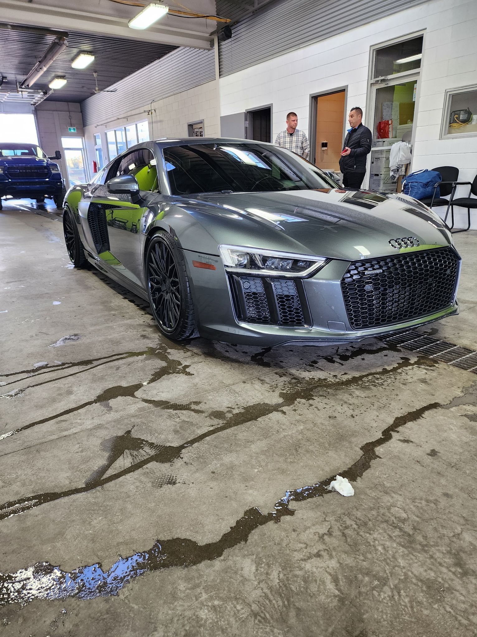Une audi r8 grise est garée dans un garage.