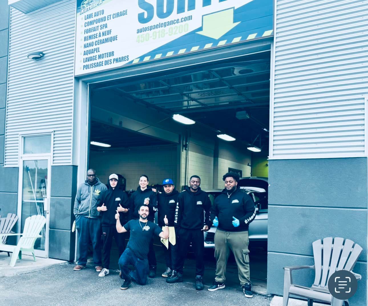 Un groupe d'hommes pose pour une photo devant une porte de garage.