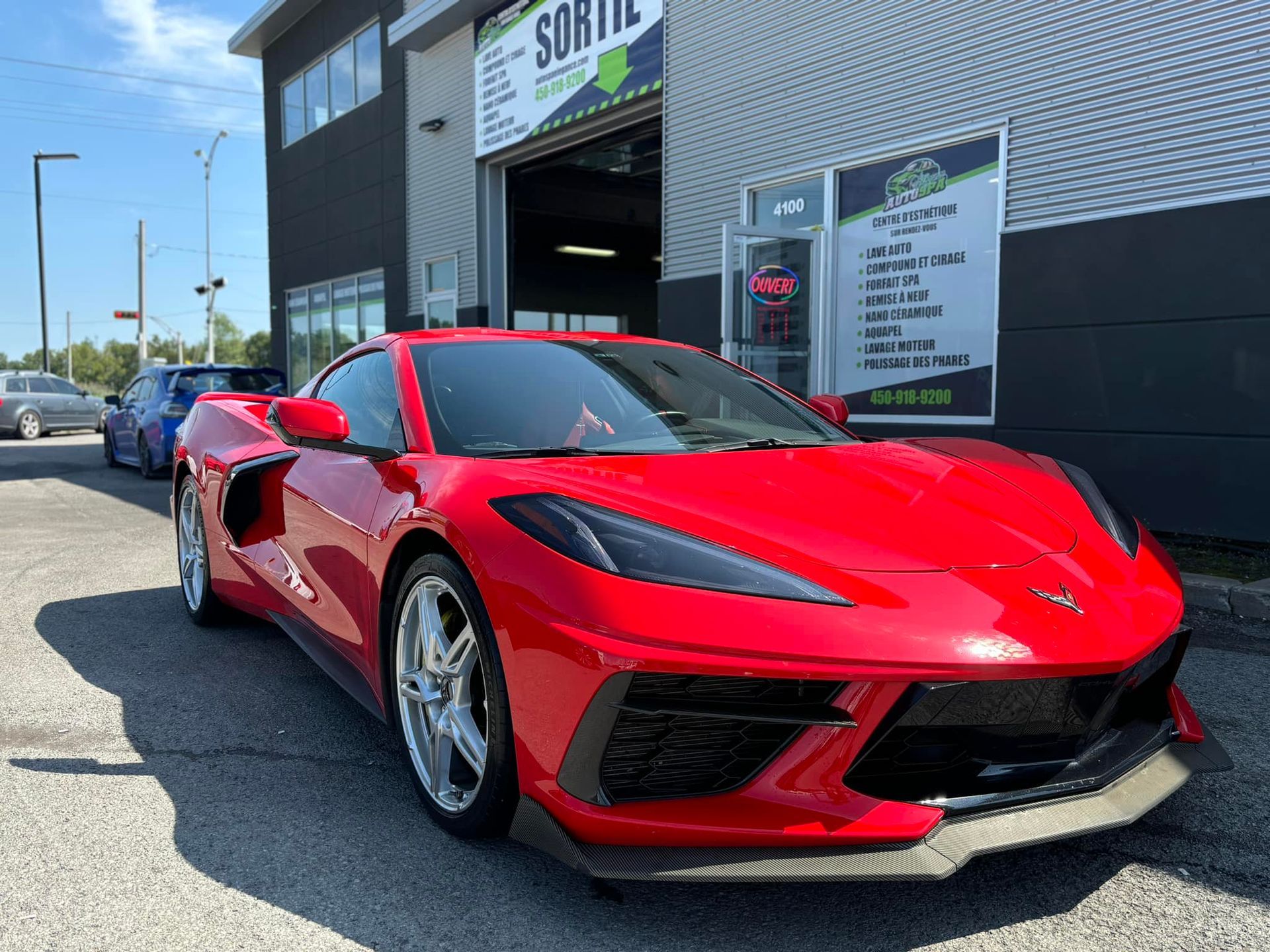 Une voiture de sport rouge est garée devant un bâtiment.