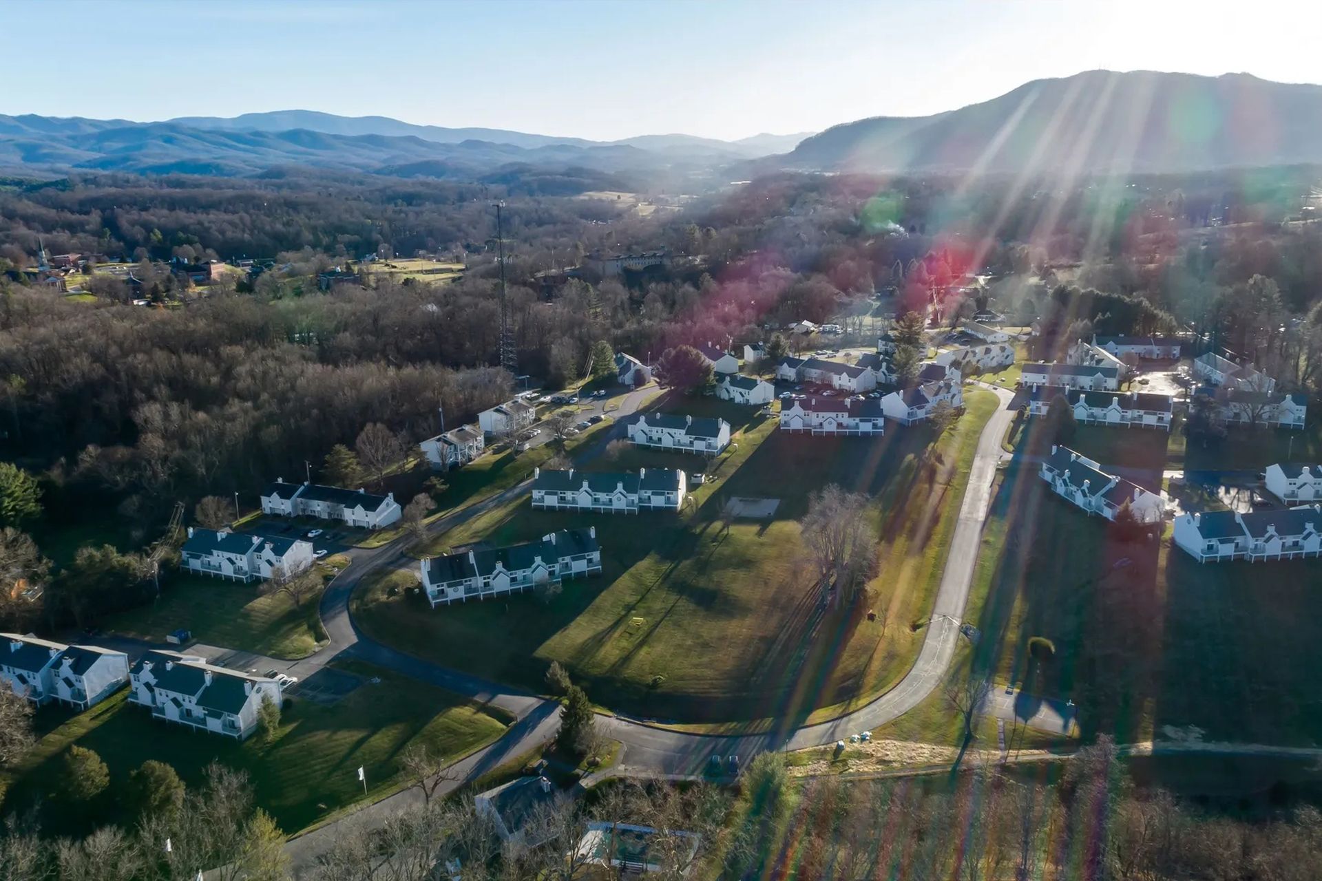 Aerial view of a residential neighborhood nestled in a valley with mountains in the background.