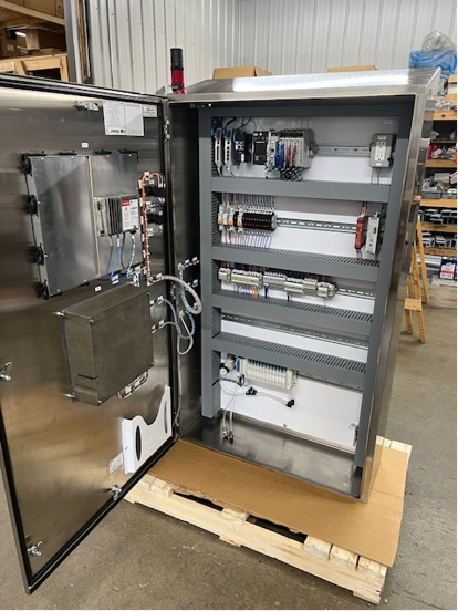 Metal control panel cabinet with open door, showing internal components.