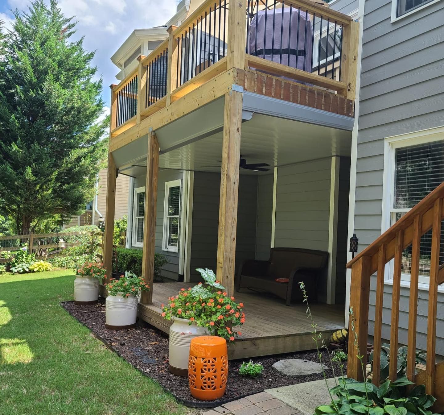 Aluminum under-deck roof that includes a hardscaping design, one ceiling fan, and outdoor lighting under construction.