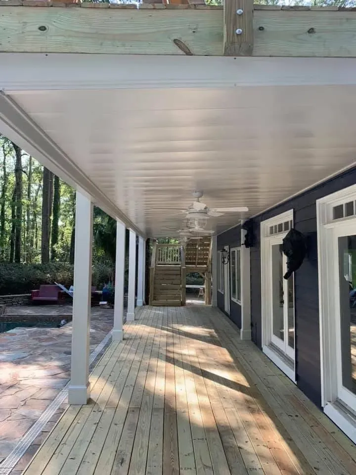 After installing white aluminum under deck ceiling system with two ceiling fans and LED lighting features.