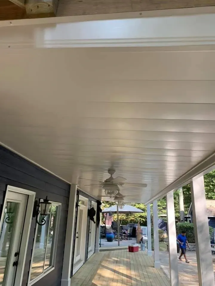 After installing white aluminum under deck drainage system with three added ceiling fans and outdoor lighting features.