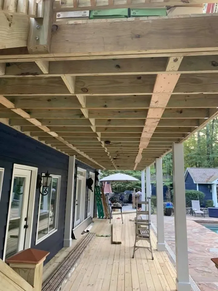 Before installing white aluminum under deck drainage system with three added ceiling fans and outdoor lighting features.