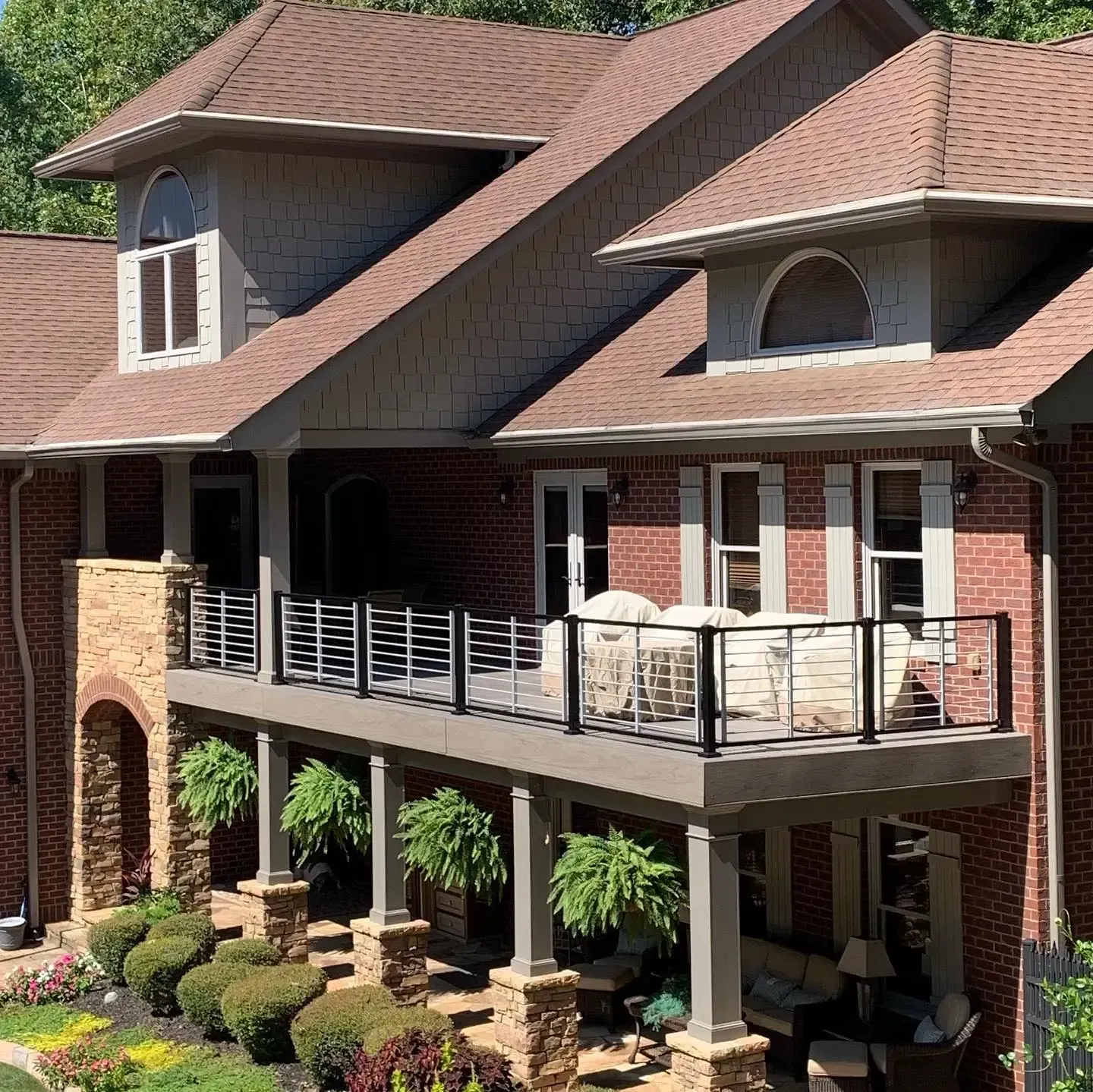 Aluminum under-deck ceiling that includes a hardscaping design, two ceiling fans, and outdoor lighting.