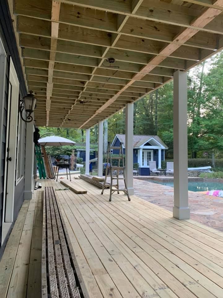 Aluminum under-deck roof that includes a hardscaping design, two ceiling fans, and outdoor lighting under construction.