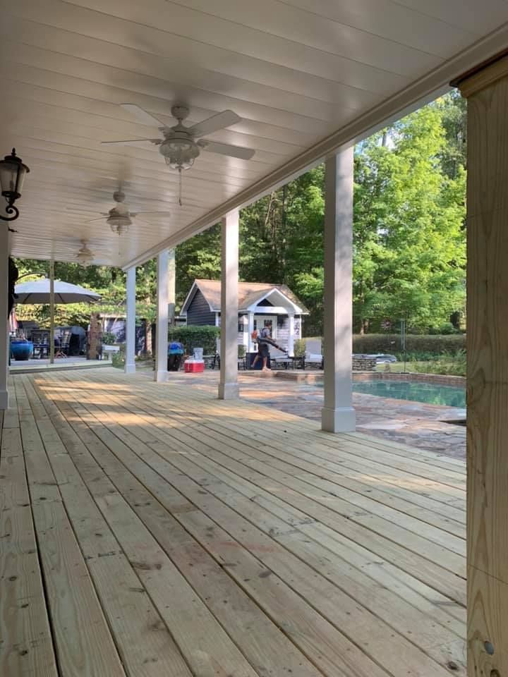 White aluminum under-deck roof that includes a hardscaping design, two ceiling fans, and outdoor lighting under construction.