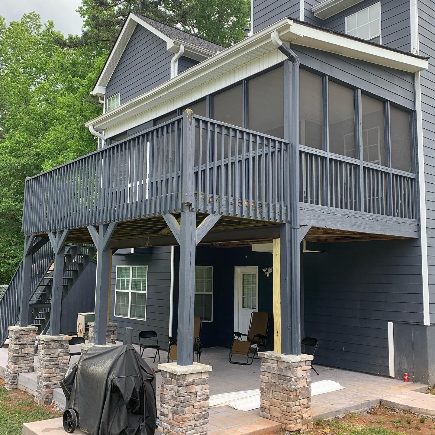 Black aluminum under-deck ceiling that includes a hardscaping design, ceiling fan, and outdoor lighting.