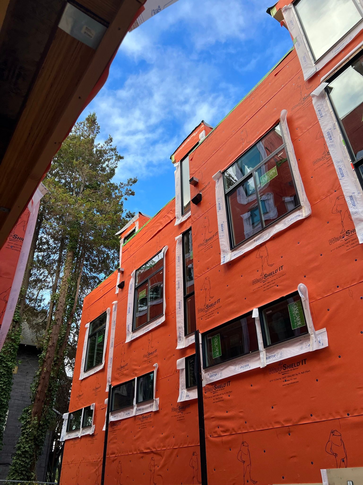 Looking up at a large orange building with lots of windows.