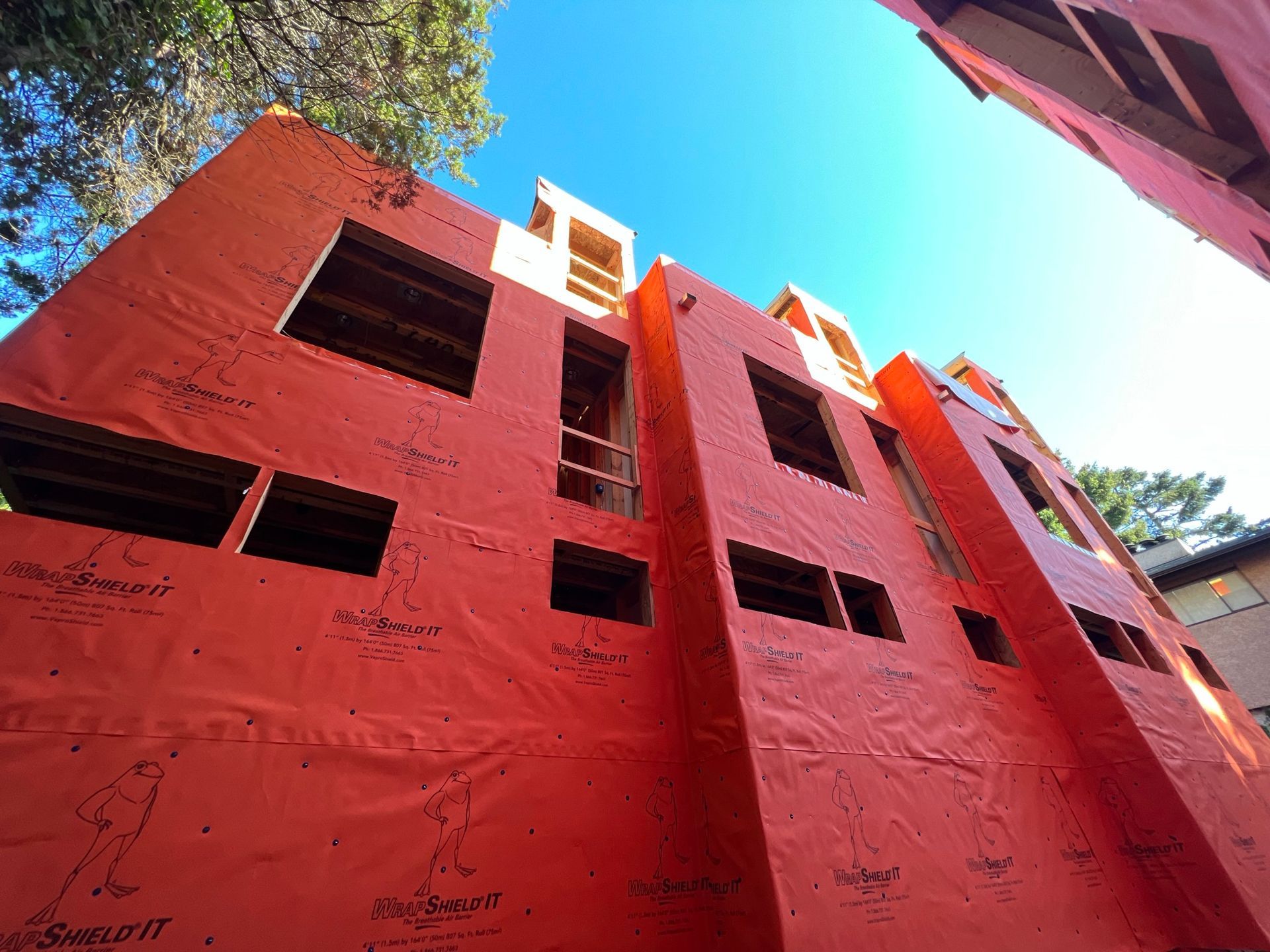 Looking up at a building under construction with a blue sky in the background.