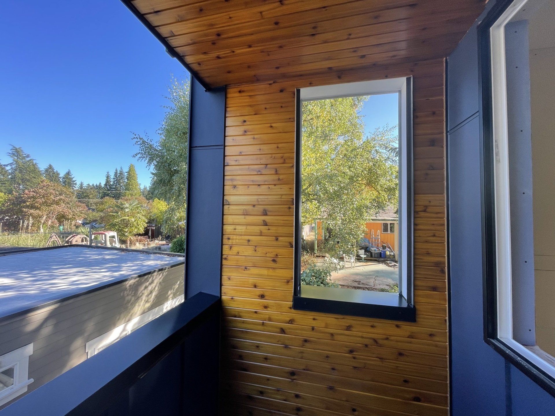 A balcony with a wooden ceiling and a large window