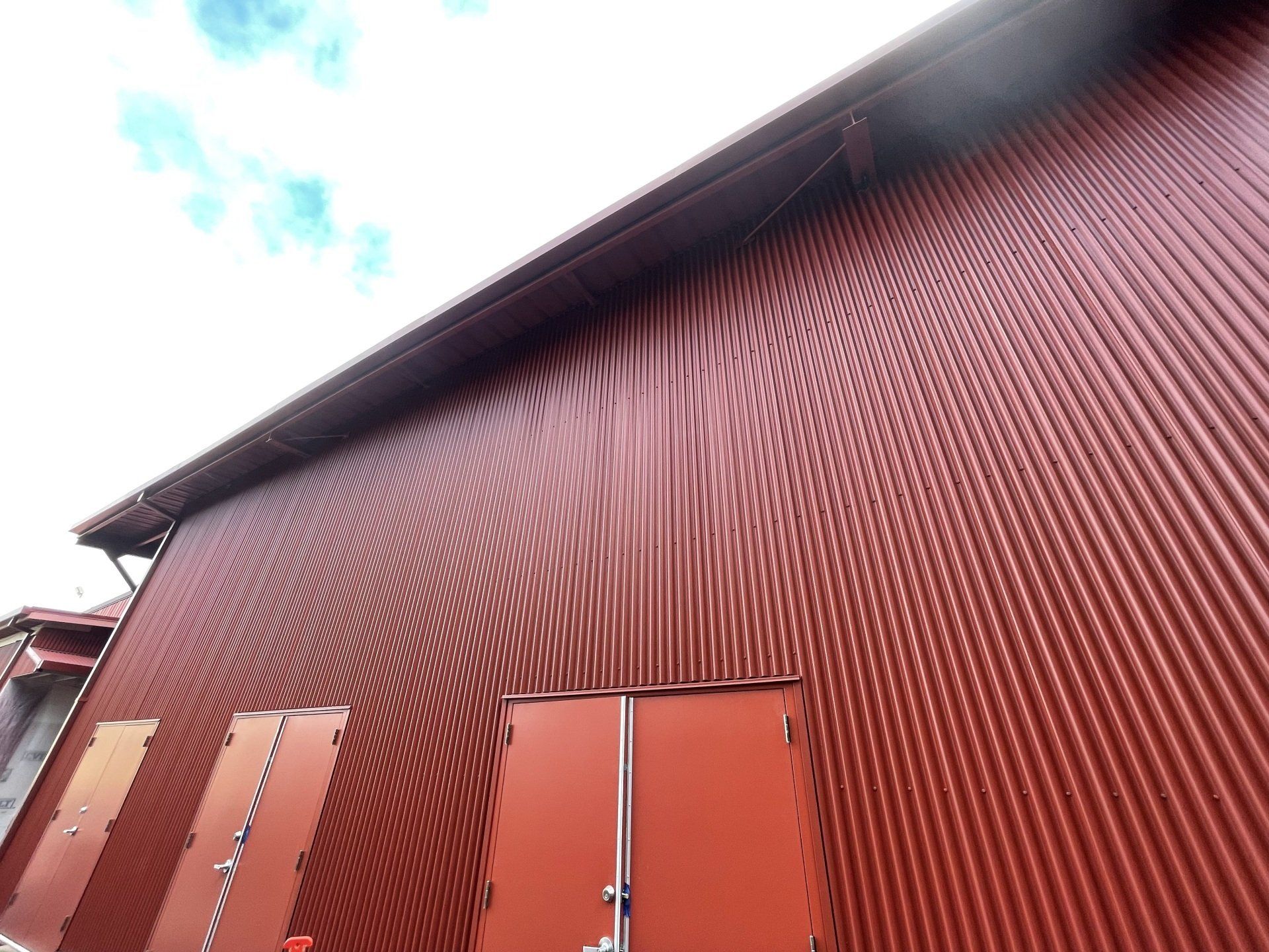 Looking up at a red building with two doors