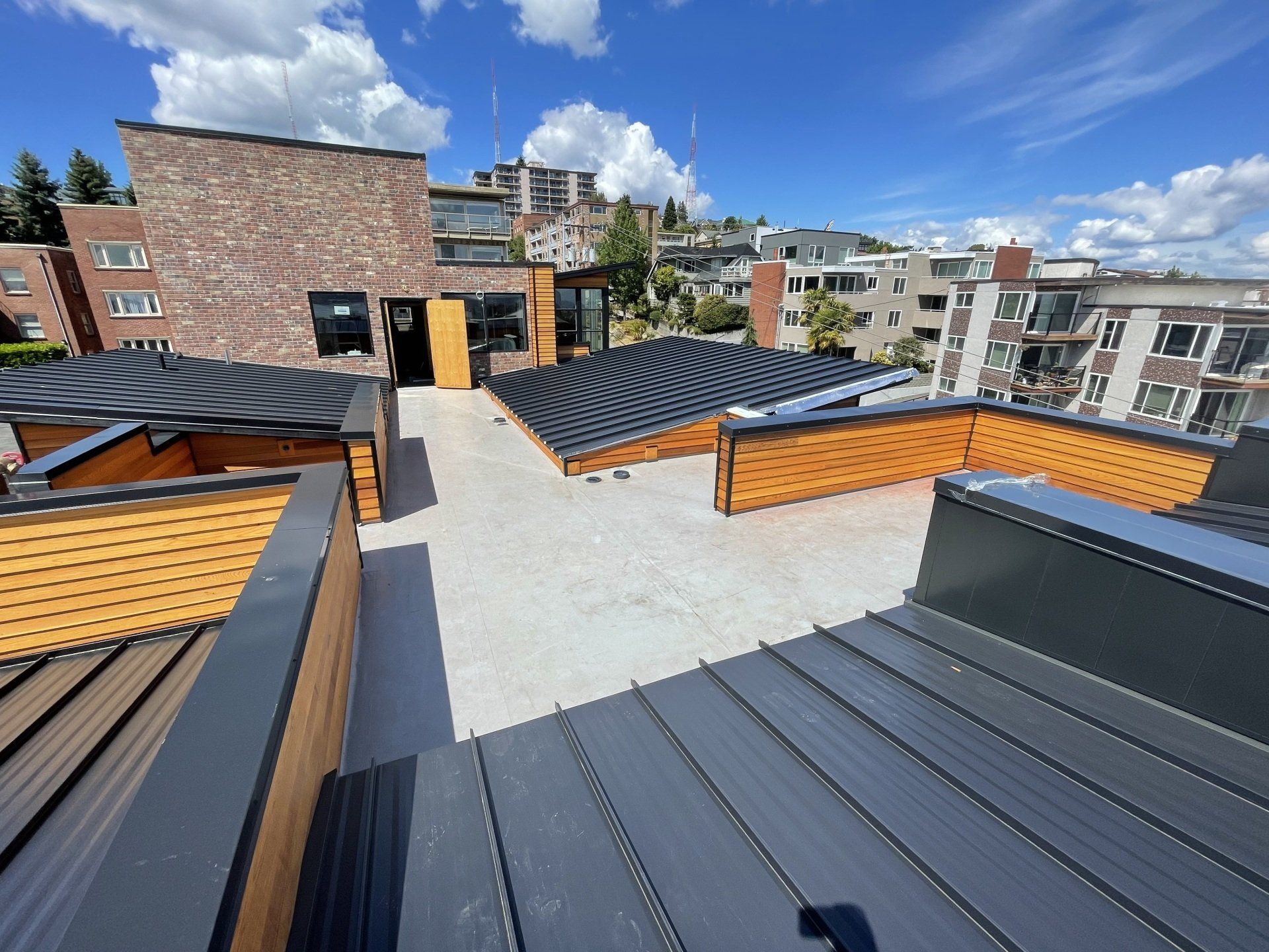 A rooftop deck with a brick building in the background