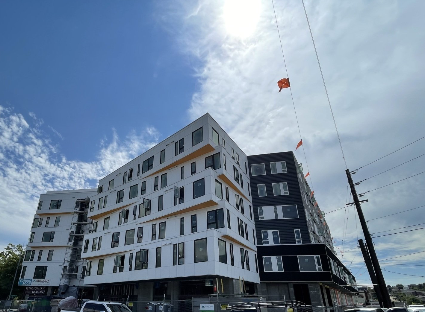 A large building under construction with a kite flying in the sky.