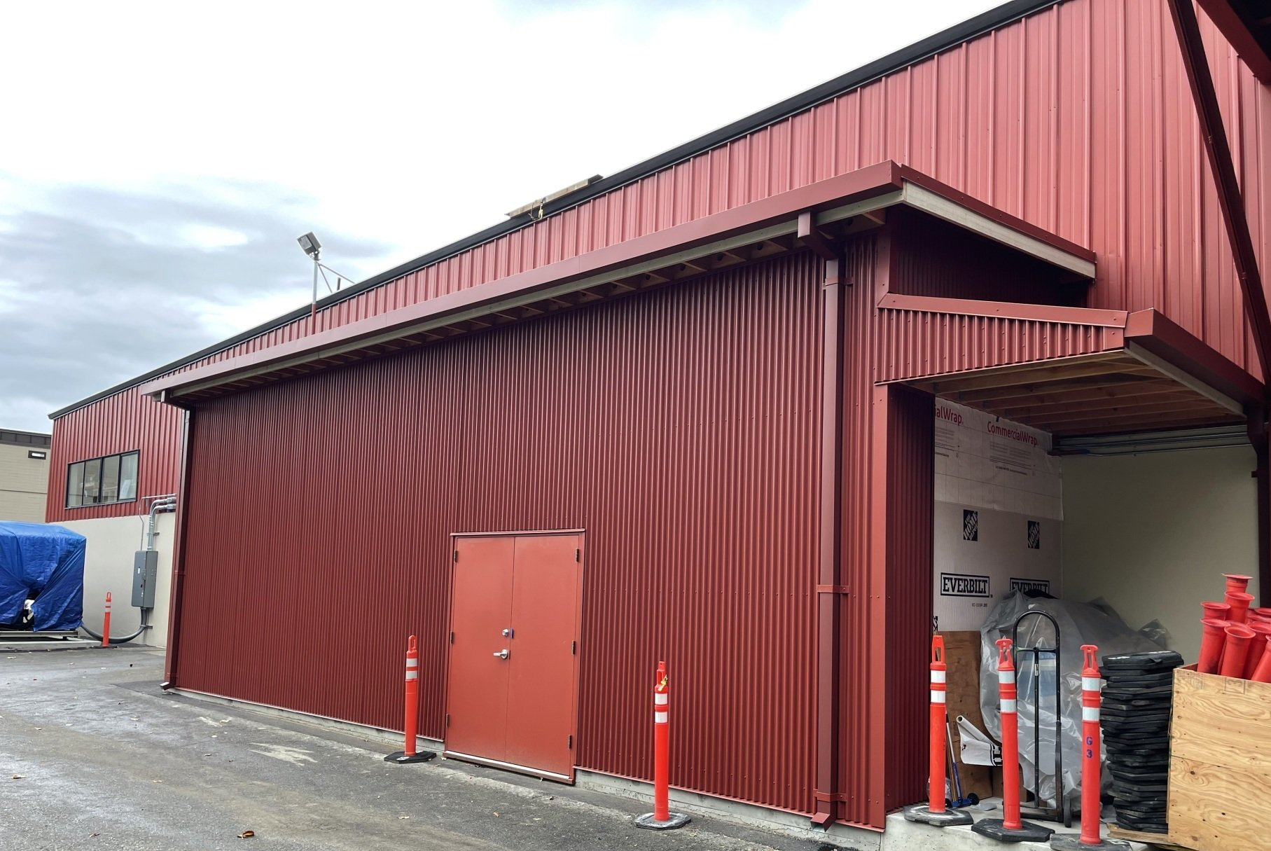 A large red building with a door and a roof is being built.