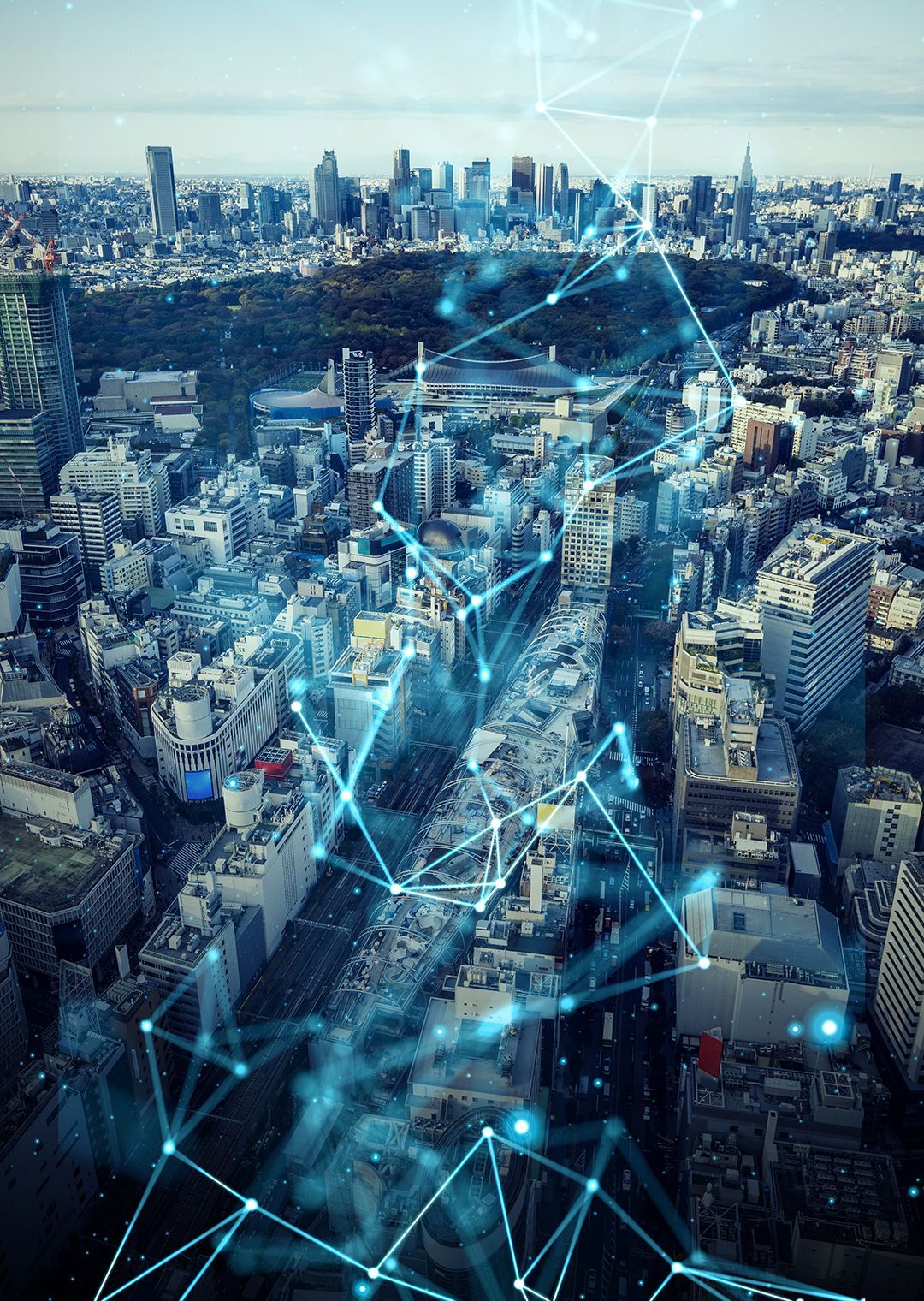 An aerial view of a sprawling cityscape overlaid with a glowing blue digital network of connected nodes and lines.