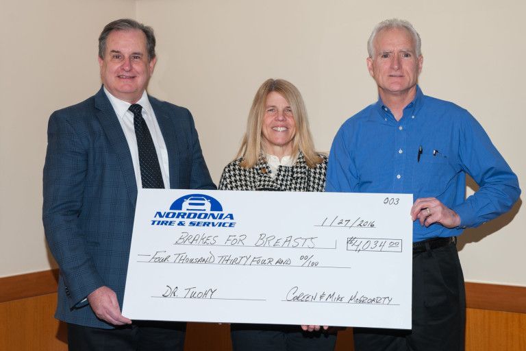 Dr. Tuohy, Coreen and Mike McGroarty receiving a check from Nordonia Tire & Service | Brakes For Breasts