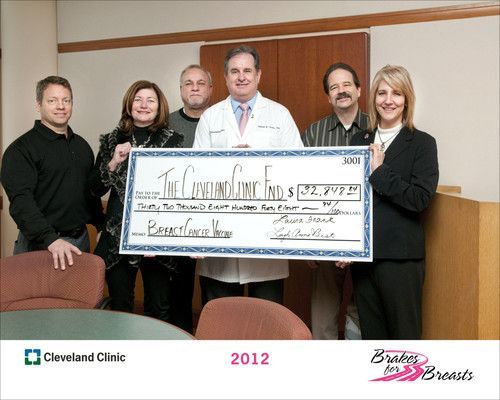 Dr. Tuohy holding large check for The Cleveland Clinic Fund | Brakes For Breasts